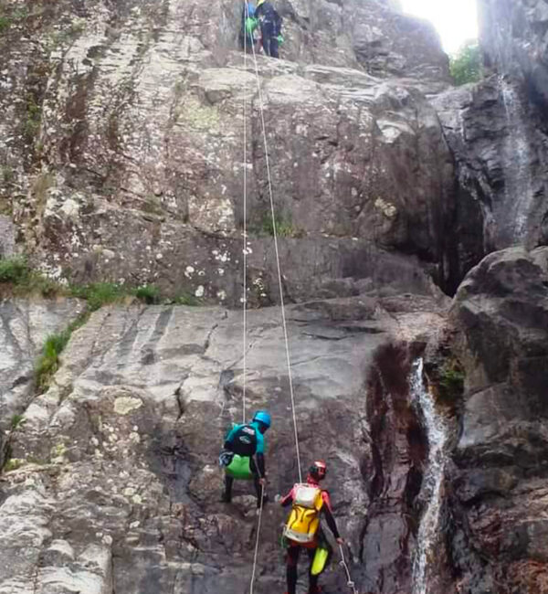 Personnes qui descendent en rappel dans un canyon.