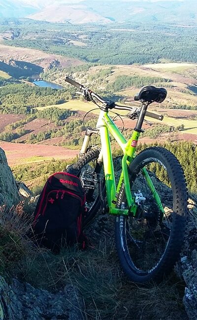 VTT posé contre les rochers face à la vallée.